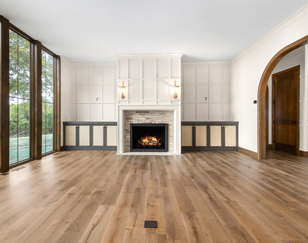 Living room with paneled fireplace wall and wood floors